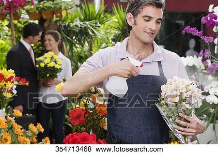 Florist working in a greenhouse View Large Photo Image Stock Photo - Florist working in a greenhouse. Fotosearch