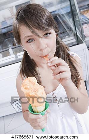 Girl eating an ice cream View Large Photo Image Stock Image - Girl eating an ice cream. Fotosearch