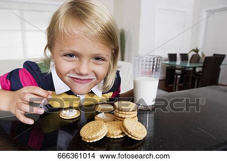 Girl having cookies and milk View Large Photo Image Picture - Girl having cookies and milk. Fotosearch