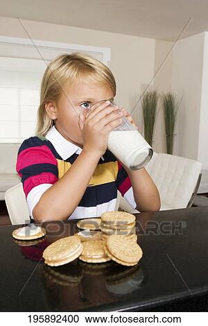 Stock Image - Girl having cookies and milk. Fotosearch