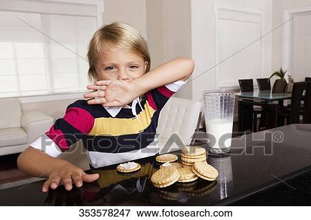 Girl having cookies and milk View Large Photo Image Stock Photo - Girl having cookies and milk. Fotosearch