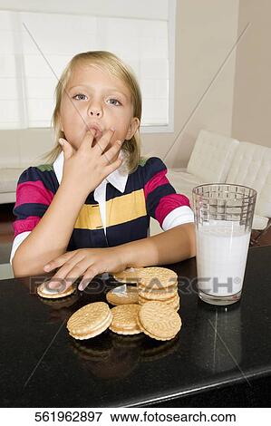 Girl having cookies and milk View Large Photo Image Stock Photo - Girl having cookies and milk. Fotosearch