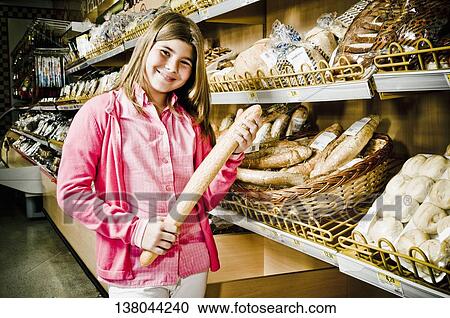 Girl holding a loaf of bread in a supermarket View Large Photo Image Stock Image - Girl holding a loaf of bread in a supermarket. Fotosearch