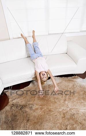 Girl playing on a couch in a living room View Large Photo Image Stock Image - Girl playing on a couch in a living room. Fotosearch