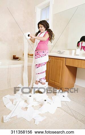Stock Photograph - Girl playing with toilet paper rolls in the bathroom. Fotosearch