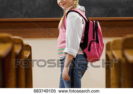 Girl standing in a classroom View Large Photo Image Stock Photography - Girl standing in a classroom. Fotosearch