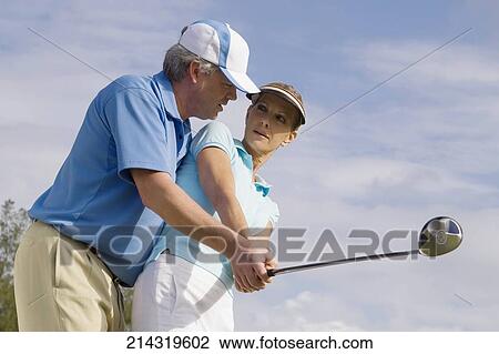 Golf instructor teaching golf to a woman, Biltmore Golf Course, Coral Gables, Florida, USA View Large Photo Image Stock Image - Golf instructor teaching golf to a woman, Biltmore Golf Course, Coral Gables, Florida, USA. Fotosearch