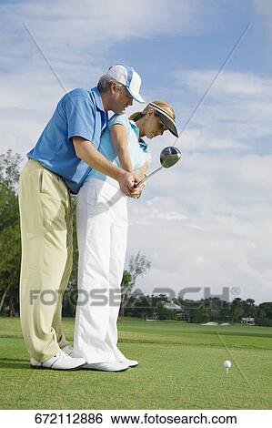 Golf instructor teaching golf to a woman, Biltmore Golf Course, Coral Gables, Florida, USA View Large Photo Image Stock Photograph - Golf instructor teaching golf to a woman, Biltmore Golf Course, Coral Gables, Florida, USA. Fotosearch