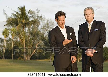 Golfer text messaging with another golfer standing beside him, Biltmore Golf Course, Coral Gables, Florida, USA View Large Photo Image Stock Image - Golfer text messaging with another golfer standing beside him, Biltmore Golf Course, Coral Gables, Florida, USA. Fotosearch