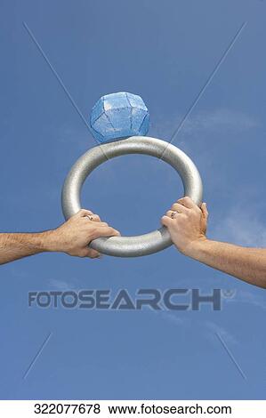 Stock Photo - Hands of a gay couple holding a giant wedding ring, DuPont Circle, Washington DC, USA. Fotosearch
