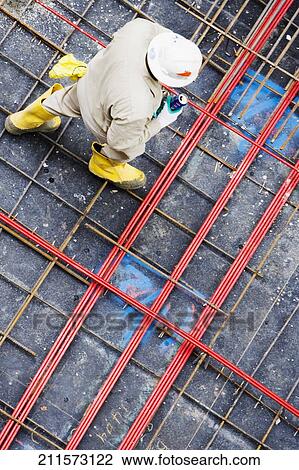 High angle view of a construction worker walking and holding a can View Large Photo Image Stock Image - High angle view of a construction worker walking and holding a can. Fotosearch