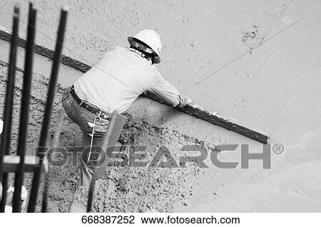 Stock Image - High angle view of a construction worker working at a construction site. Fotosearch