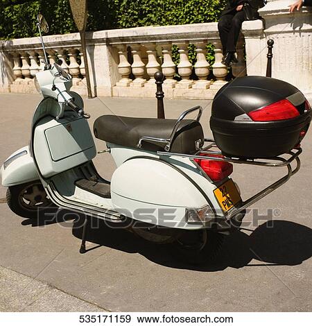 High angle view of a motor scooter parked at the roadside View Large Photo Image Stock Photo - High angle view of a motor scooter parked at the roadside. Fotosearch