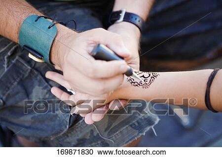 High angle view of a person's hand drawing a tattoo on a hand View Large Photo Image Stock Image - High angle view of a person's hand drawing a tattoo on a hand. Fotosearch