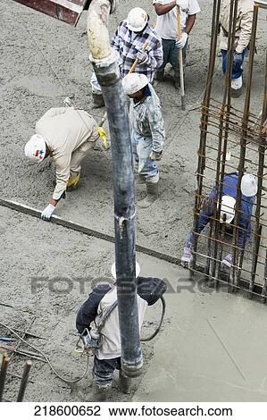 Stock Image - High angle view of construction workers working at a construction site. Fotosearch