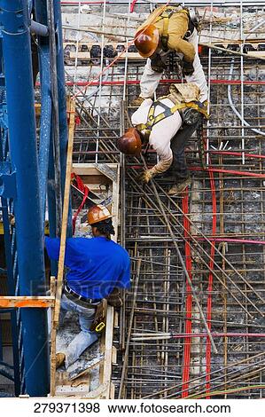 Stock Photo - High angle view of construction workers working at a construction site. Fotosearch