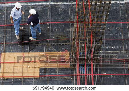 High angle view of two architects standing at a construction site View Large Photo Image Stock Image - High angle view of two architects standing at a construction site. Fotosearch