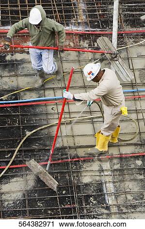 High angle view of two construction workers working at a construction site View Large Photo Image Stock Image - High angle view of two construction workers working at a construction site. Fotosearch