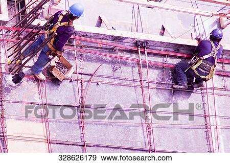 High angle view of two construction workers working at a construction site View Large Photo Image Stock Photo - High angle view of two construction workers working at a construction site. Fotosearch