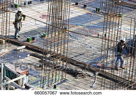 Stock Photo - High angle view of two construction workers working at a construction site. Fotosearch