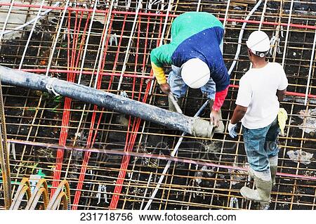 High angle view of two construction workers working at a construction site View Large Photo Image Stock Photograph - High angle view of two construction workers working at a construction site. Fotosearch