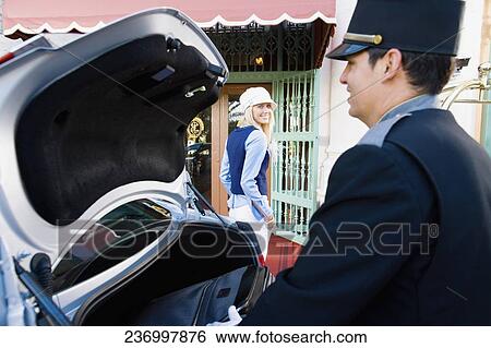 Stock Photograph - Hotel porter carrying luggage from a car, Biltmore Hotel, Coral Gables, Florida, USA. Fotosearch