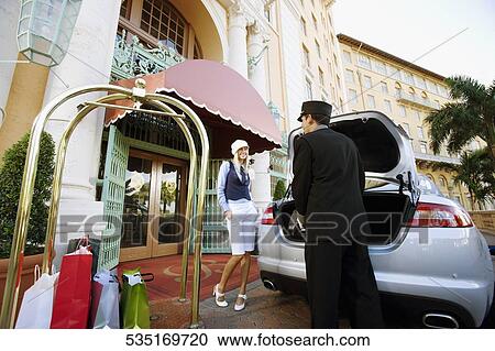 Hotel porter carrying luggage with a woman standing, Biltmore Hotel, Coral Gables, Florida, USA View Large Photo Image Stock Image - Hotel porter carrying luggage with a woman standing, Biltmore Hotel, Coral Gables, Florida, USA. Fotosearch