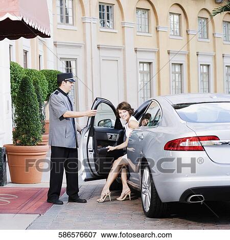Stock Photo - Hotel porter opening car door for a woman, Biltmore Hotel, Coral Gables, Florida, USA. Fotosearch