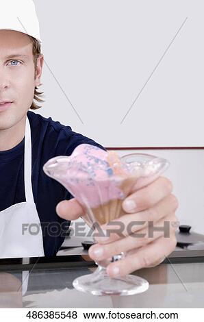 Stock Photo - Ice cream seller holding a glass of ice cream. Fotosearch