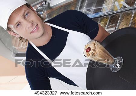Ice cream seller holding a tray with a glass of ice cream View Large Photo Image Stock Photo - Ice cream seller holding a tray with a glass of ice cream. Fotosearch