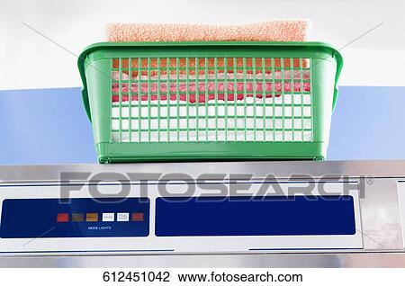 Laundry basket on a washing machine in a laundromat View Large Photo Image Stock Image - Laundry basket on a washing machine in a laundromat. Fotosearch
