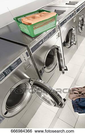 Stock Photograph - Laundry basket on a washing machine in a laundromat. Fotosearch
