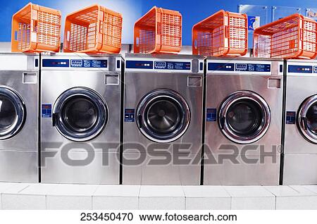 Laundry baskets on washing machines in a laundromat View Large Photo Image Stock Image - Laundry baskets on washing machines in a laundromat. Fotosearch