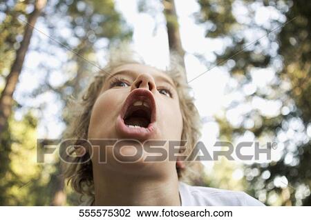 Stock Image - Low angle view of a girl shouting. Fotosearch