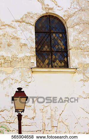 Stock Photo - Low angle view of a lamppost in front of a wall. Fotosearch