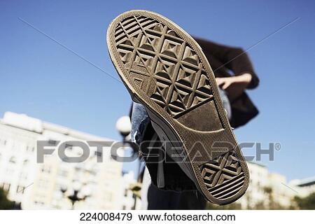 Low angle view of a person showing his shoe View Large Photo Image Stock Photo - Low angle view of a person showing his shoe. Fotosearch