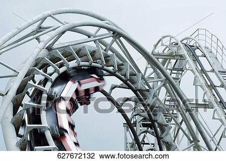 Stock Image - Low angle view of a rollercoaster in motion. Fotosearch