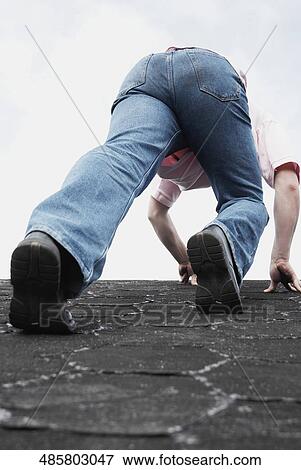 Low angle view of a young man climbing on a wall View Large Photo Image Stock Photo - Low angle view of a young man climbing on a wall. Fotosearch