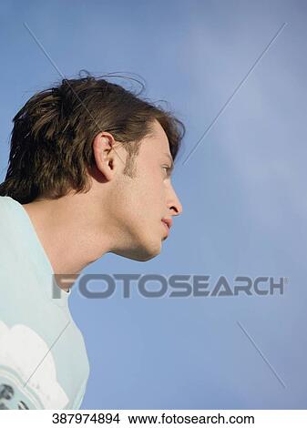 Low angle view of a young man looking up View Large Photo Image Picture - Low angle view of a young man looking up. Fotosearch