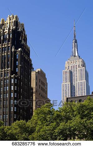 Low angle view of skyscrapers in a city, Empire State skyscraper, Manhattan, Bryant Park, New York City, New York State, USA View Large Photo Image Stock Photograph - Low angle view of skyscrapers in a city, Empire State skyscraper, Manhattan, Bryant Park, New York City, New York State, USA. Fotosearch