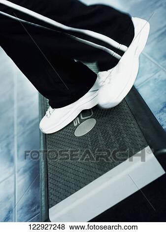 Low section view of a woman doing step aerobics in a gym View Large Photo Image Stock Photo - Low section view of a woman doing step aerobics in a gym. Fotosearch