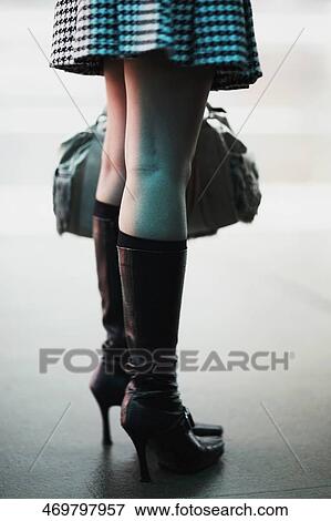 Low section view of a woman holding a bag View Large Photo Image Stock Photo - Low section view of a woman holding a bag. Fotosearch