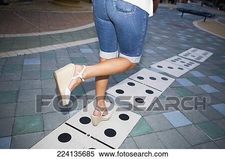 Stock Photography - Low section view of a woman walking on a tiled floor. Fotosearch