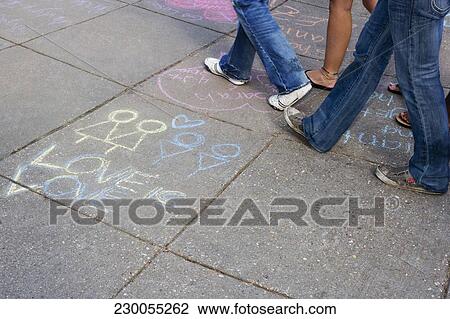 Stock Image - Low section view of people walking over chalk drawings on the road, DuPont Circle, Washington DC, USA. Fotosearch