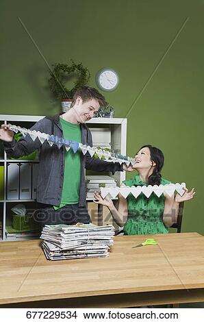 Picture - Man and a woman holding paper chains. Fotosearch