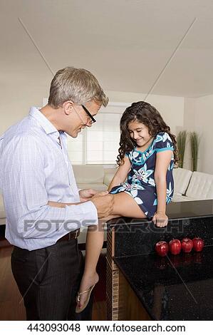 Man applying bandage on his daughter's knee View Large Photo Image Stock Photo - Man applying bandage on his daughter's knee. Fotosearch