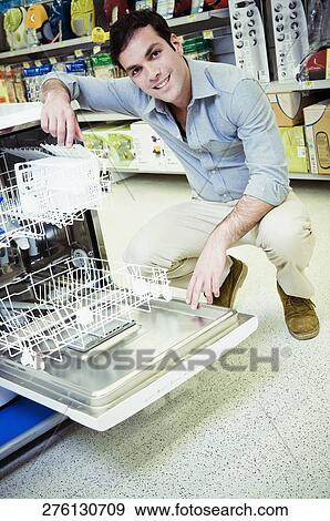 Man buying a dishwasher in a supermarket View Large Photo Image Stock Photo - Man buying a dishwasher in a supermarket. Fotosearch