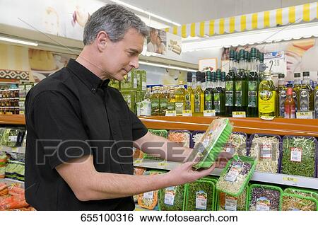 Man buying food in a supermarket View Large Photo Image Stock Photograph - Man buying food in a supermarket. Fotosearch