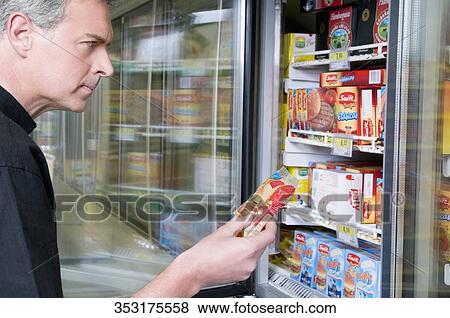 Stock Photo - Man buying packed food in a supermarket. Fotosearch