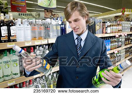 Man buying vodka bottles in a liquor store View Large Photo Image Stock Image - Man buying vodka bottles in a liquor store. Fotosearch